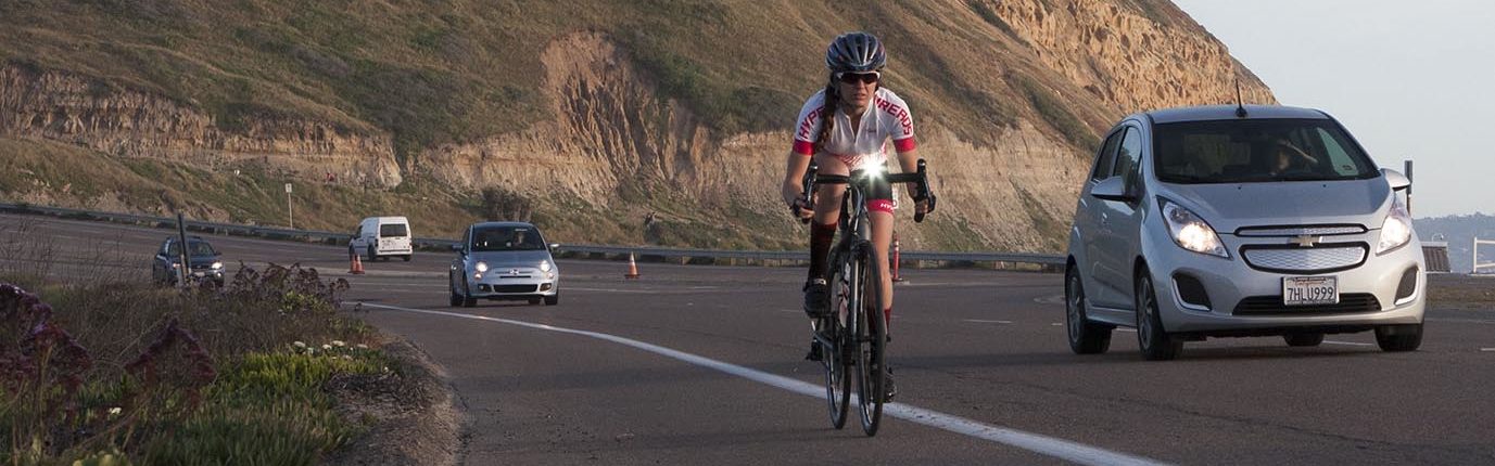 Woman on bike with bright flashing headlight for daytime